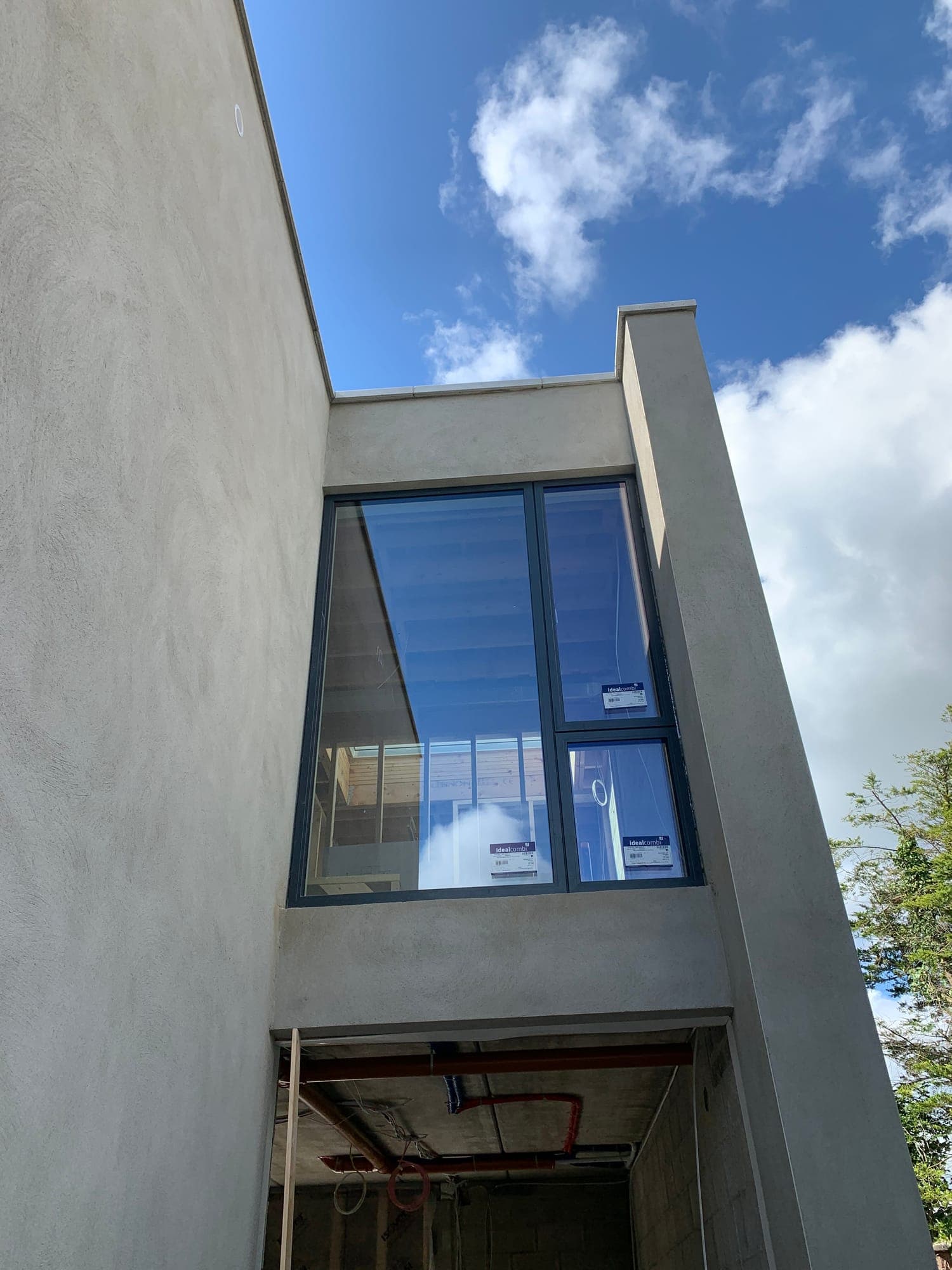 Double-height aluminium windows on a modern home, installed by MDM Windows & Doors