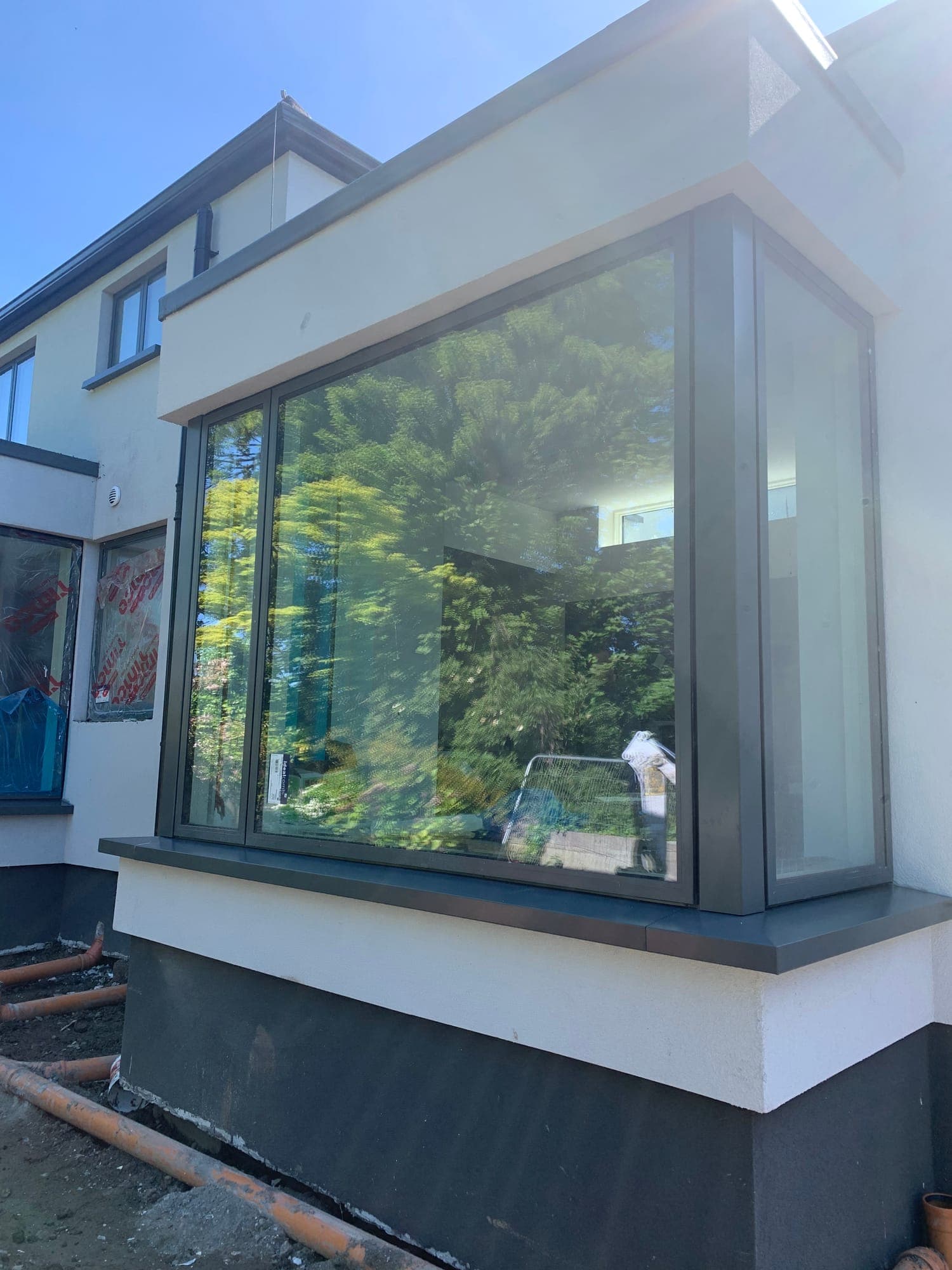 Sunlit glazed corner box window projecting from a rendered home, installed by MDM Windows & Doors