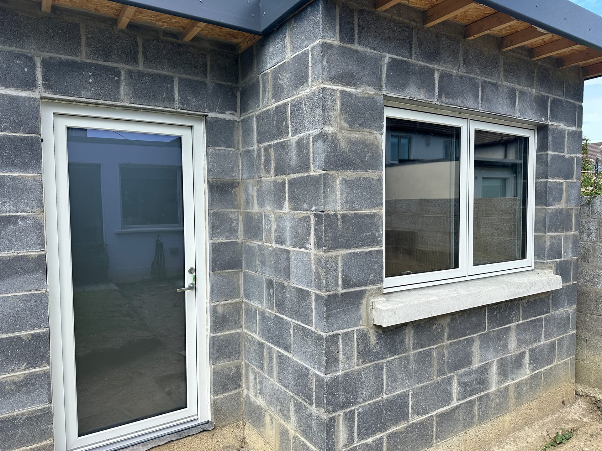 White aluminium garden door beside a matching window opening onto a patio, installed by MDM Windows & Doors in Dublin